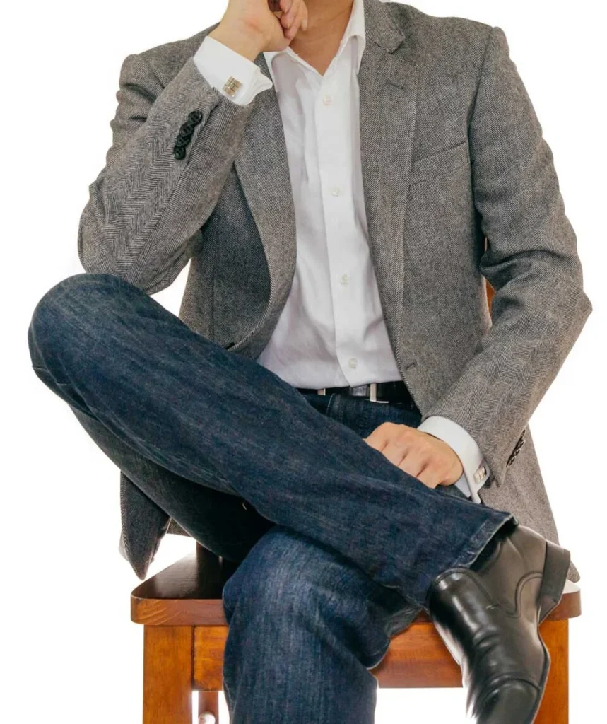 ジャケットと襟付きシャツ、デニム、革靴を組み合わせた男性のスマートカジュアル例